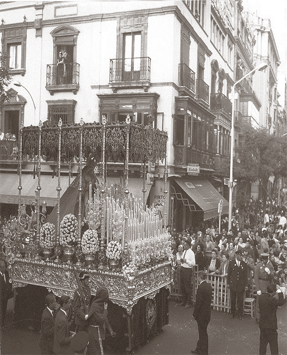 Año de 1963. Tarde de Jueves Santo en Sevilla. El paso de la Virgen de Las Lágrimas, se dispone a revirar desde el Duque a Campana.