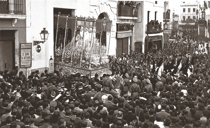 Tarde del Jueves Santo de 1941: Vemos a la Virgen del rosario de Montensión saliendo a una abarrotada Plaza de los Carros.