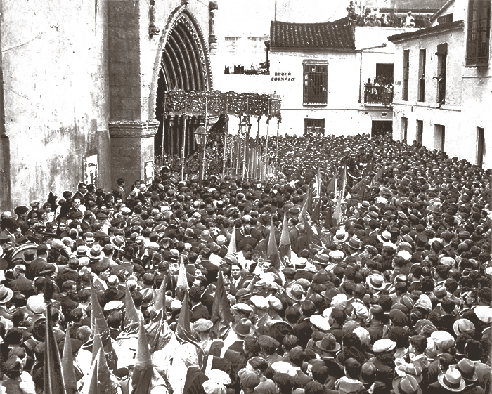 Justo saliendo desde su Templo de San Julián vemos al paso de palio de la Virgen de la Hiniesta en la tarde del Domingo de Ramos de 1931.Siendo que al año siguiente, la Virgen y la Iglesia serían pasto de las llamas. Fotografía: ABC.